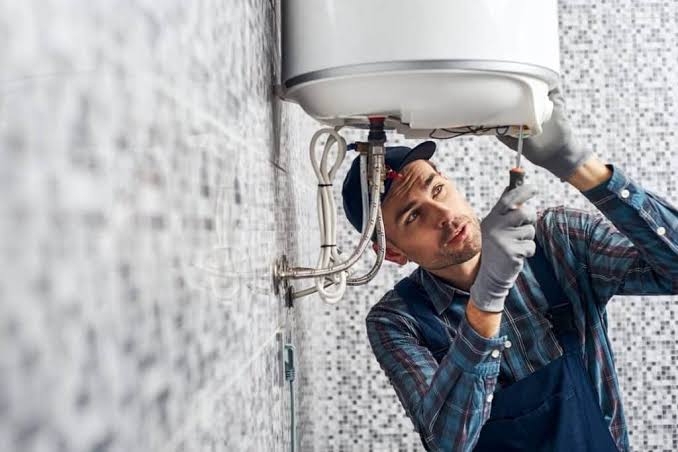 Technician repairing a water heater