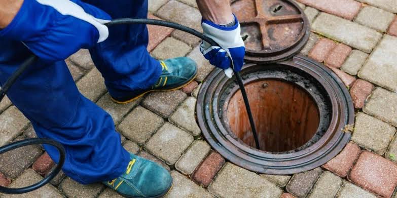 Technician cabling a main sewer line cleanout